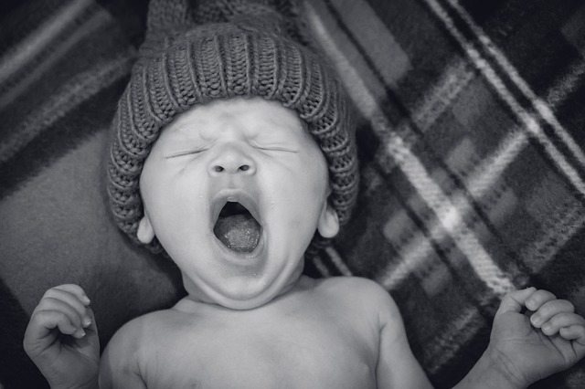 a black and white picture of a baby yawning